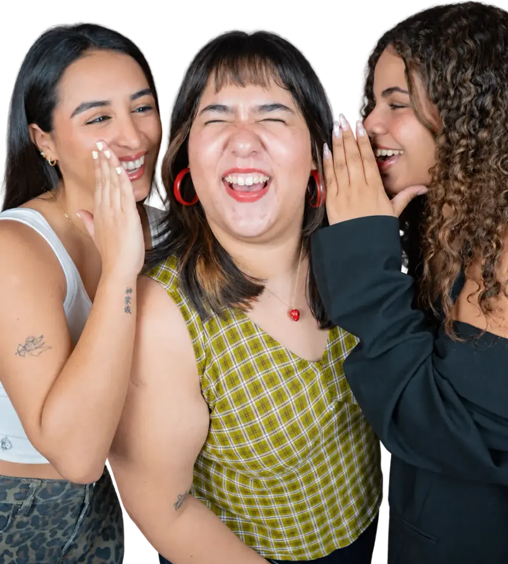 Las tres hosts de QUÉ FOMO! riéndose mientras se cuentan un chisme al oído