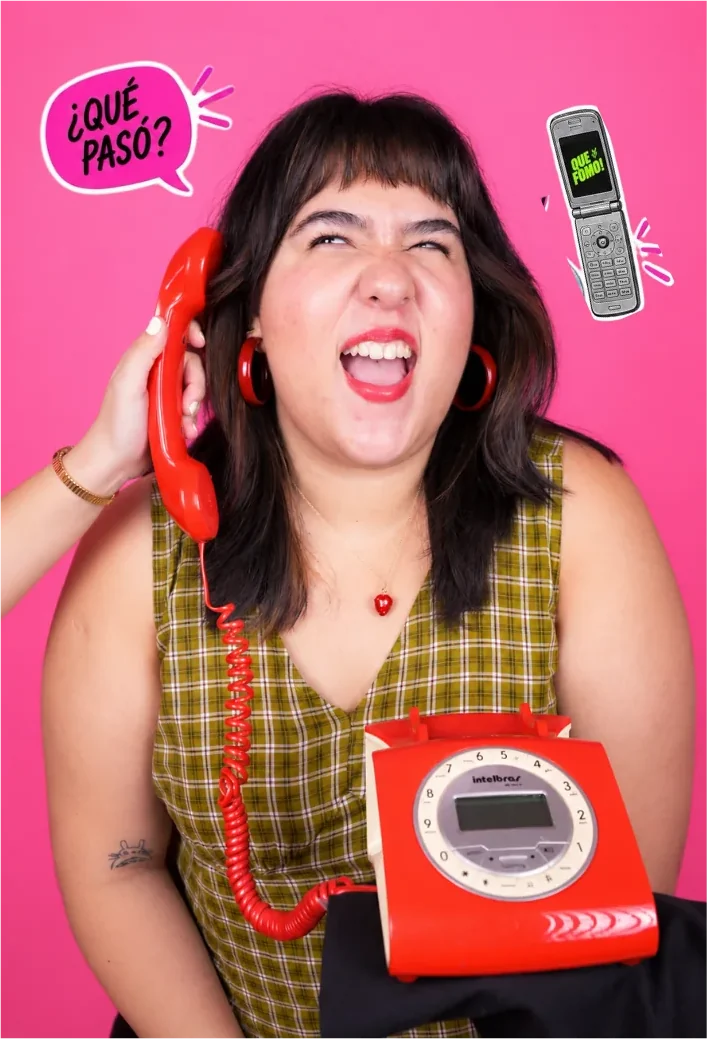 Una de las host gritando por el teléfono rojo bajo un bocadillo que dice ¿qué pasó?